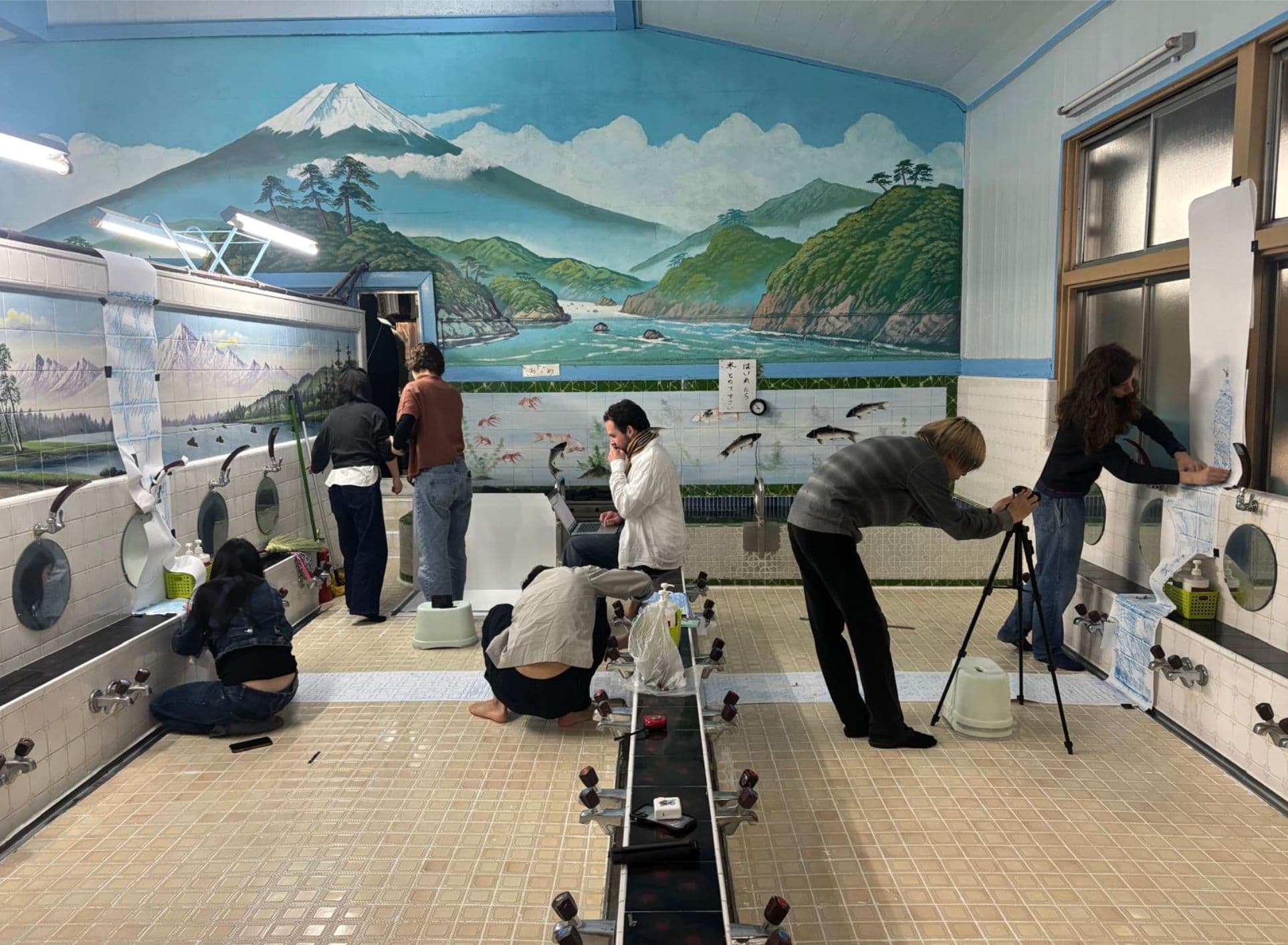 Photograph of people in a wash room taking tile rubbings from the walls