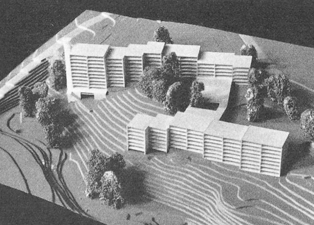Architectural model of a modern multi-story building complex on a terraced, sloped landscape.