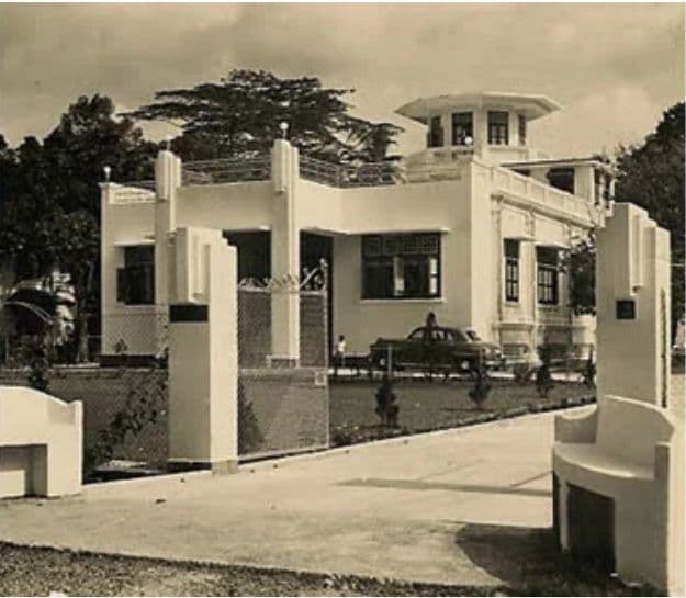 A colonial-era white house with a distinctive circular tower and minimalist architectural features.