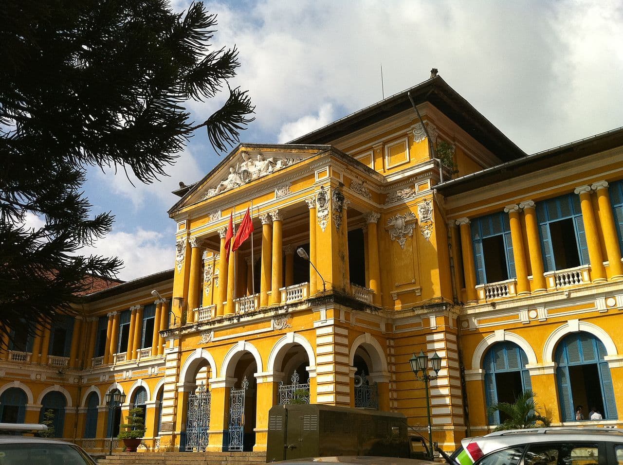 Ornate yellow building with a red flag flying from a balcony.