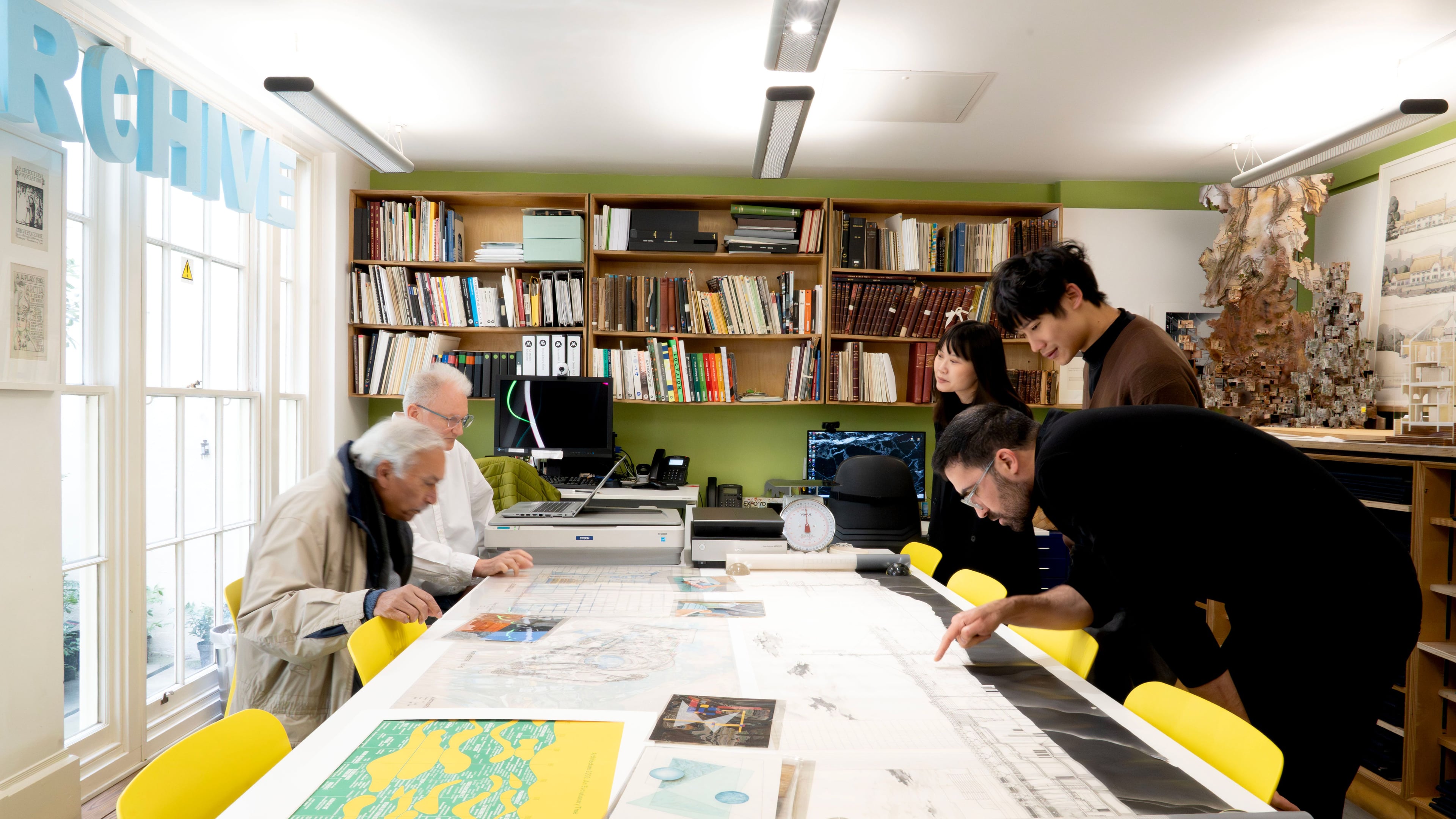 Four people in the AA Archives with the Head of Archives looking at documents