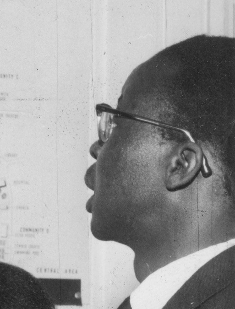 Black and white profile of a man wearing glasses, speaking or listening intently.