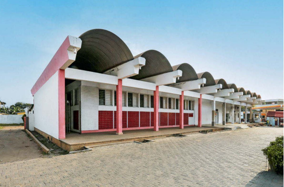 A modern building with a distinctive wavy roof and red and white facade.