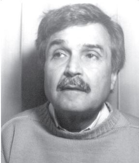 Black and white portrait of a man with a mustache looking thoughtfully upwards.