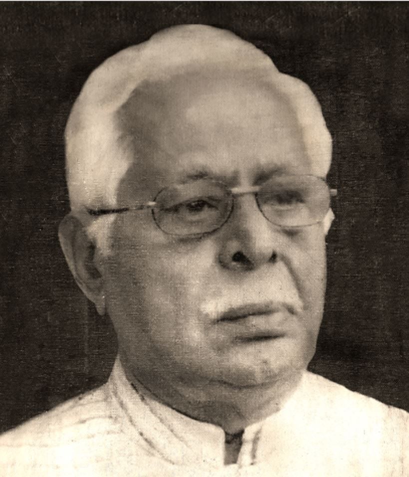 Elderly man with white hair, spectacles, and a mustache looking contemplatively.