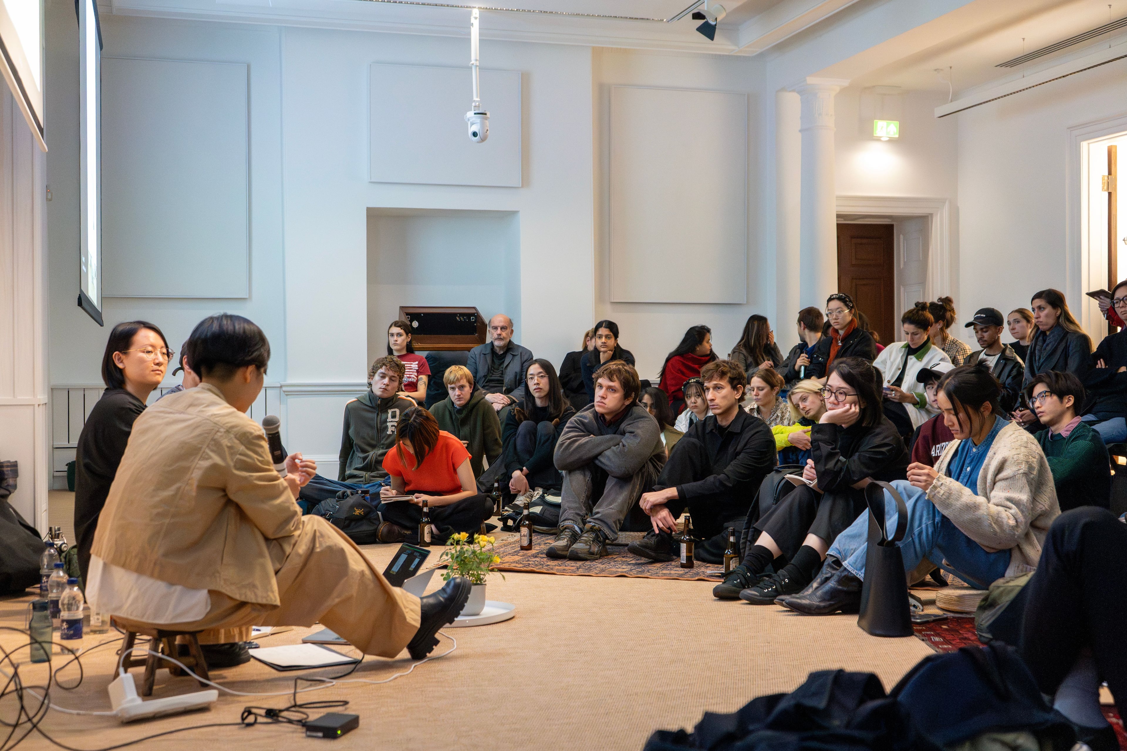 A group sitting on the floor of the AA Lecture Hall.